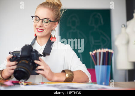 Femme photographe regardant ses images Banque D'Images