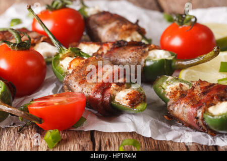 Apéritif : épicée jalapeno poivrons farcis au fromage enrobé de bacon sur la table horizontale. Banque D'Images