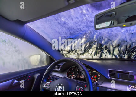 Voiture dans une station de lavage automatique, le nettoyage du site est pulvérisé sur la mousse, la rotation de la brosse de nettoyage, Banque D'Images