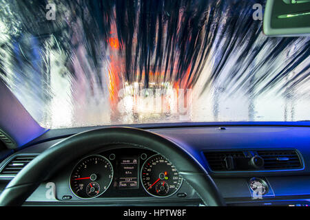 Voiture dans une station de lavage automatique, le nettoyage du site est pulvérisé sur la mousse, la rotation de la brosse de nettoyage, Banque D'Images