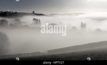 Mist passe au-dessus d'une combe ou coombe une vallée contenant le village de Dunsford dans la Teign Valley,s/n et de chaume,blanchis Dartmoor National Park Banque D'Images