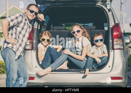 Famille heureuse de se préparer pour road trip sur une journée ensoleillée. Concept de famille accueillante. Banque D'Images