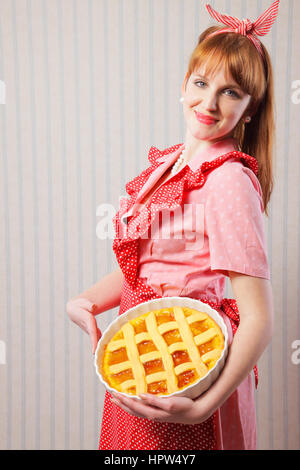 Retro housewife holding hot italian pie. Banque D'Images
