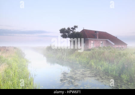 Gîte rural la rivière par dans le brouillard au lever du soleil Banque D'Images