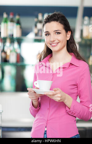 Happy smiling waitress dans un café servant un expresso chaud Banque D'Images