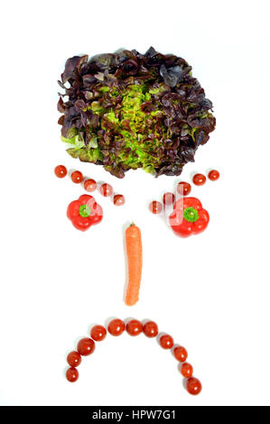 Un visage en colère, avec des légumes, salade, poivrons, carottes, tomates. Banque D'Images