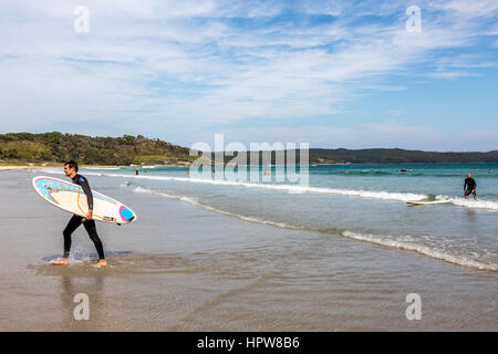 Homme portant un surf à populaires Cave Beach dans le parc national Booderee, Jervis Bay, Australie Banque D'Images