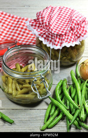 Accueil haricots verts en conserve sur table en bois Banque D'Images