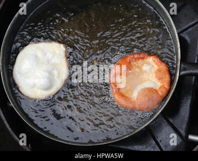 Deux crêpes frits dans une casserole d'huile chaude dans un stand de l'alimentation de rue en Europe Banque D'Images