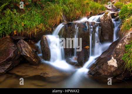 Belle cascade dans les montagnes avec de l'eau mousseuse blanche Banque D'Images