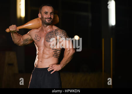 Jeune homme exerçant avec Bowling Pin et Flexing Muscles - Athletic musculaire Fitness Exercices Modèle Bodybuilder Banque D'Images