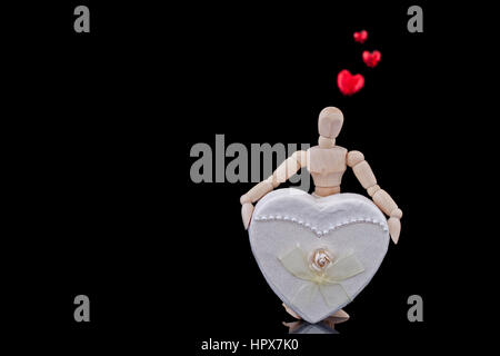 Un mannequin holding a présent fort sur fond noir Banque D'Images