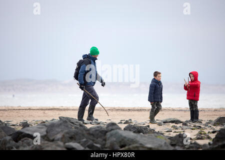 Une famille dont le père et les deux fils, bénéficiant d'une plage à pied en hiver sur la plage de Newborough sur l'île d'Anglesey, au Pays de Galles, Royaume-Uni Banque D'Images