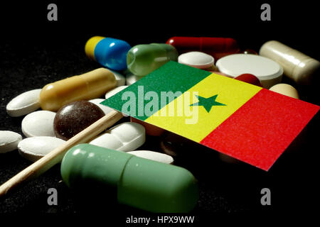 Pavillon sénégalais avec beaucoup de pilules médical isolé sur fond noir Banque D'Images