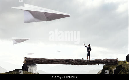 Femme élégante et big Paper Plane flying in sky. Technique mixte Banque D'Images