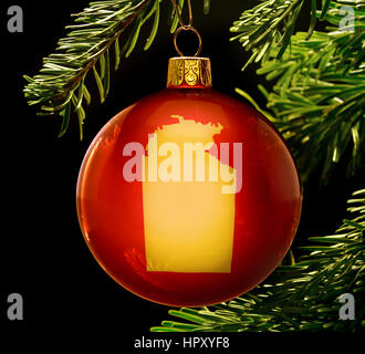 Une babiole rouge avec le Territoire du Nord de la forme d'or accroché à un arbre de Noël isolé sur noir.(série) Banque D'Images