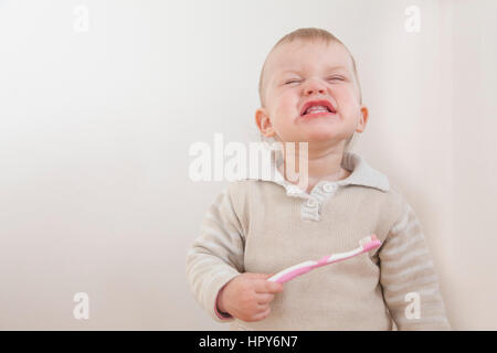 Petite fille se brosser les dents isolé sur fond blanc Banque D'Images