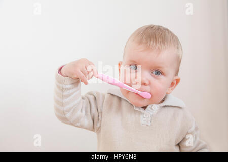 Petite fille se brosser les dents isolé sur fond blanc Banque D'Images