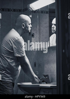 Homme d'âge moyen et les routines du matin dans la salle de bains Banque D'Images