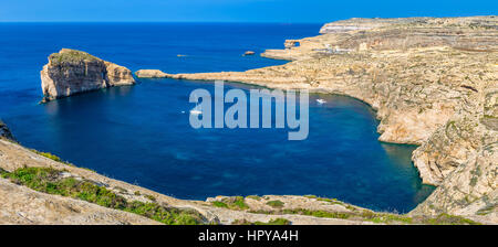 Gozo, Malte - Vue Panoramique vue sur l'horizon de Dwejra bay avec des champignons Rock, Fenêtre d'Azur et voilier sur une chaude journée d'été de nice Banque D'Images