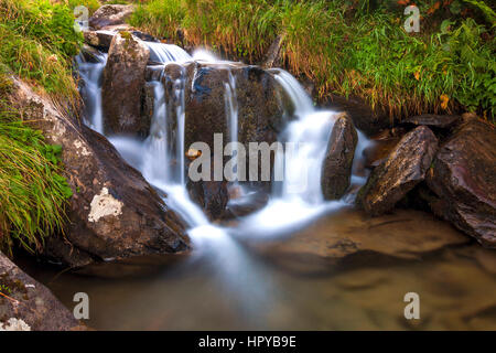 Belle cascade dans les montagnes avec de l'eau mousseuse blanche Banque D'Images