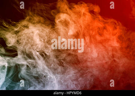 Résumé La fumée de couleur sur fond rouge Banque D'Images