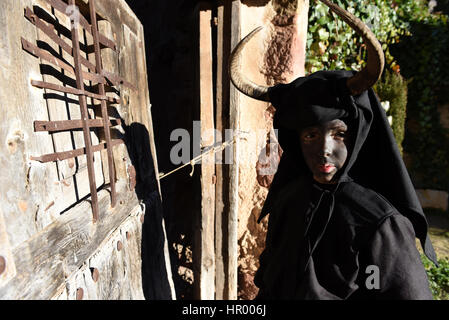 Luzón, Espagne. Feb 25, 2017. Une fille, couvertes d'huile et de suie transportant bull cornes sur sa tête et cloches sur une ceinture représentant le diable, photographié au cours d'une célébration de carnaval traditionnel dans le petit village de Luzon, Espagne. Credit : Jorge Sanz/Pacific Press/Alamy Live News Banque D'Images