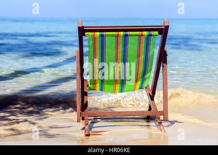 Vide chaise longue sur la plage de la mer. Président colorés est abandonné sur une plage ensoleillée. Vacances sur une île tropicale. Banque D'Images