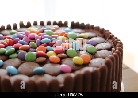 Gâteau au chocolat recouvert de chocolat chocolat les doigts, les boutons et les billes de chocolat Banque D'Images