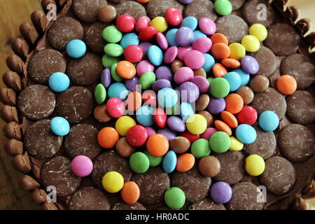 Gâteau au chocolat recouvert de chocolat chocolat les doigts, les boutons et les billes de chocolat Banque D'Images