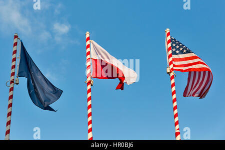 Drapeaux de l'Otan, la Pologne et USA forme piscine libre contre le ciel bleu clair. Banque D'Images