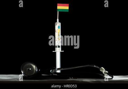 Stéthoscope et seringue remplie de l'injection de drogues drapeau Bolivien sur fond noir Banque D'Images