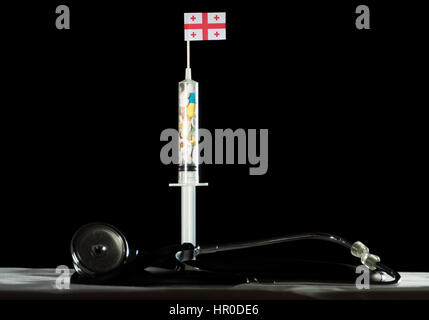 Stéthoscope et seringue remplie de l'injection de drogues drapeau géorgien sur fond noir Banque D'Images