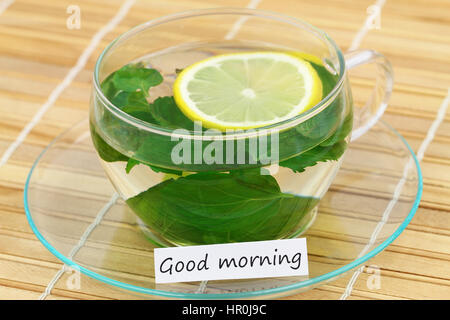 Carte de bon matin avec une tasse de thé à la menthe citron sur le tapis de bambou Banque D'Images