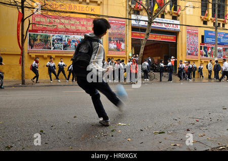 HANOI, VIETNAM - 19 février 2013 : les enfants en uniforme vietnamien jouant dans l'avant de leur école à Hanoi Banque D'Images