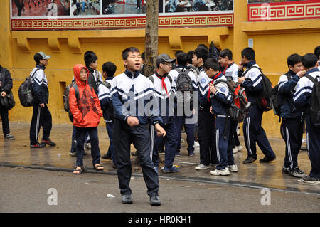 HANOI, VIETNAM - 19 février 2013 : les enfants en uniforme vietnamien jouant dans l'avant de leur école à Hanoi Banque D'Images