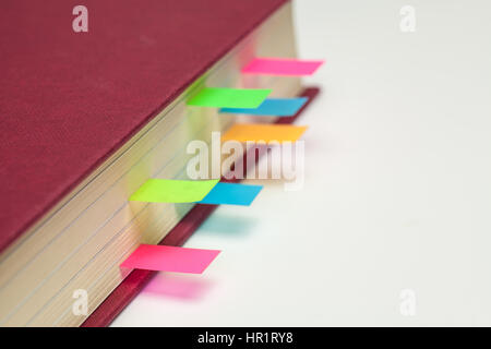 Les marqueurs de couleur Page collante dans un manuel. Banque D'Images