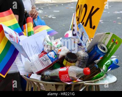 Un assortiment de boîtes de conserve, bouteilles, ordures et de drapeaux arc-en-ciel dans la corbeille après le 2015 Paris Gay Pride (Marche des Fiertés). Blvd Saint-Michel, Paris Fr Banque D'Images