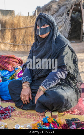 Muscat, Oman - Dec 4, 2017 : Une vieille femme omanaise habillé en vêtements traditionnels exhibant ses produits sur un marché. Banque D'Images