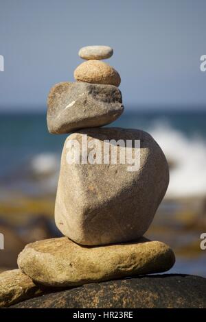 Zen - un tas de pierres assorties équilibré sur une plage en été Banque D'Images