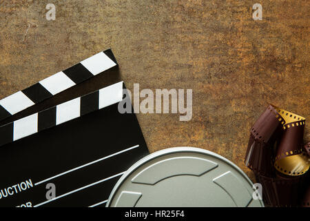 Clapper board avec bobine de film sur fond rouille. Vue d'en haut. Banque D'Images