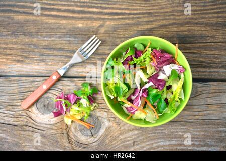 Salade verte fraîche dans un bol sur la table en bois close up Banque D'Images