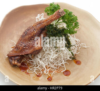 Cuisse de canard frit avec des nouilles sur la plaque brune Banque D'Images