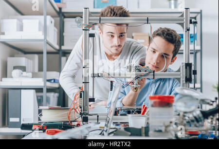 Les jeunes étudiants chercheurs à l'aide d'une imprimante 3D dans le laboratoire, l'ingénierie et de prototypage concept Banque D'Images