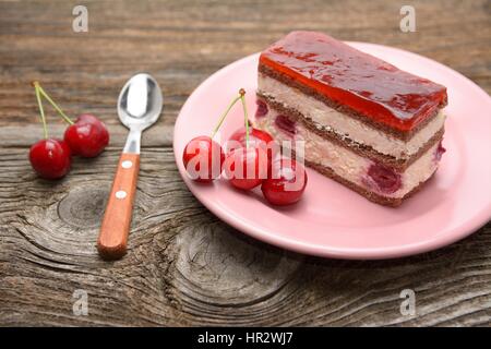 Gâteau cerises et des tranches de gâteau cerise sur fond de bois rustique Banque D'Images