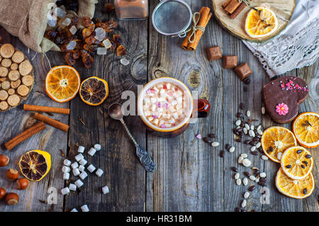 Avec des guimauves de cacao et une cuillère de fer sur la surface en bois gris y compris des chocolats et bonbons Banque D'Images