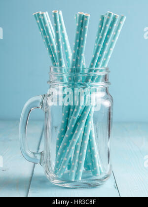 Bocaux Mason avec pailles en papier bleu sur bleu fond de bois. Idéal pour l'été des boissons et smoothies. La verticale Banque D'Images