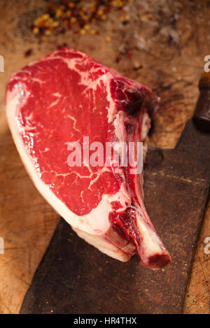 La viande de boeuf cru steak sur table en bois avec couperet à viande et d'épices Banque D'Images