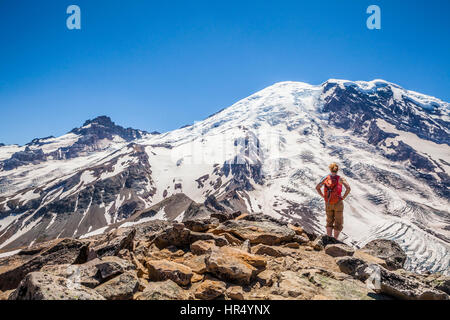 Une femme hiker scrambling sur les roches sur la montagne, 3e Burroughs Mount Rainier National Park, Washington, USA Banque D'Images