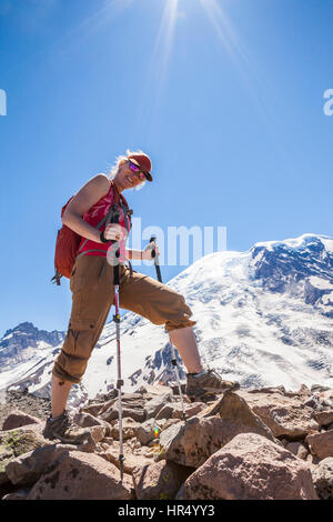 Une femme hiker scrambling sur les roches sur la montagne, 3e Burroughs Mount Rainier National Park, Washington, USA Banque D'Images